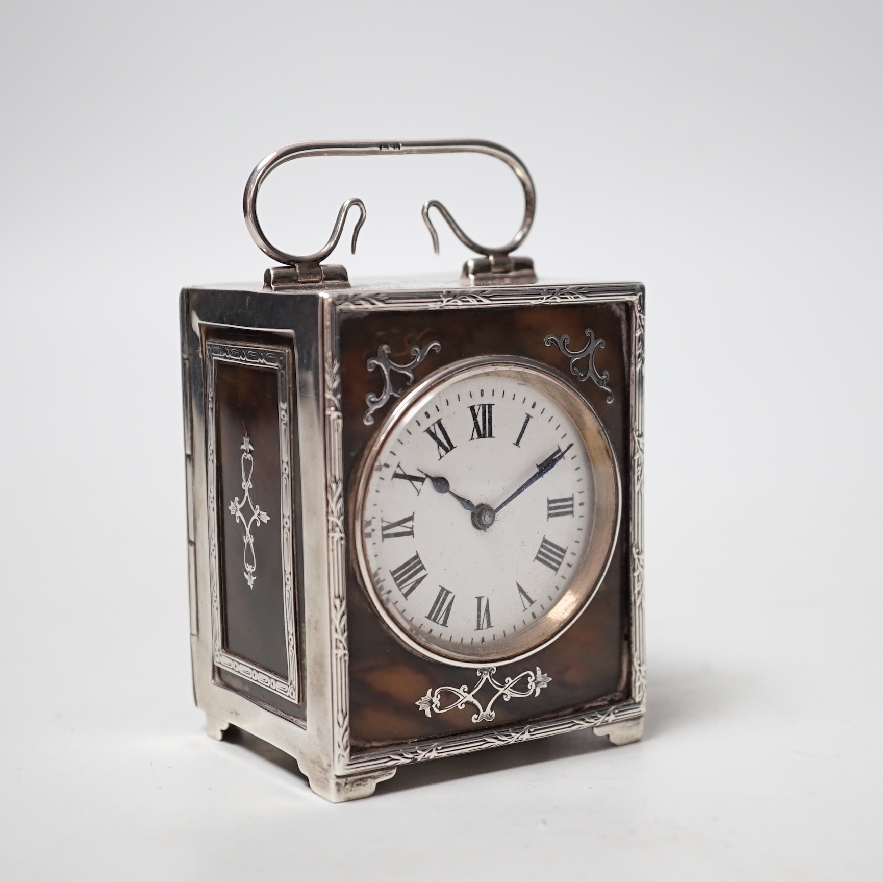 An Edwardian silver and tortoiseshell mounted carriage timepiece, with Roman dial, maker's mark rubbed, Birmingham, 1909, overall height 10cm.